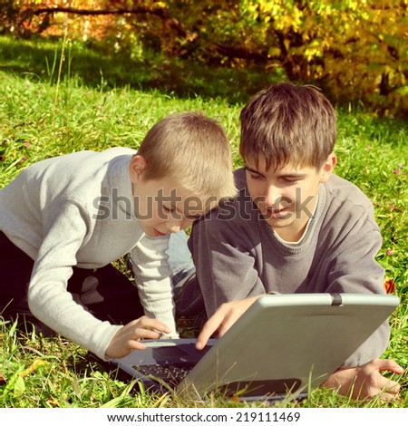 Toned photo of Happy Brothers with Laptop outdoor
