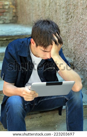 Sad Teenager with Tablet Computer on the landing steps of the House