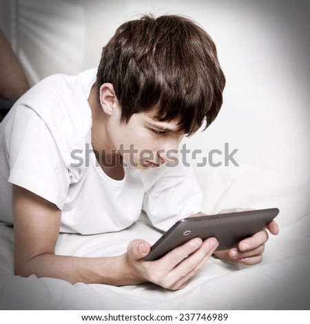Sad Teenager with Tablet Computer at the Home