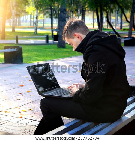 Young Man with Laptop in the Park