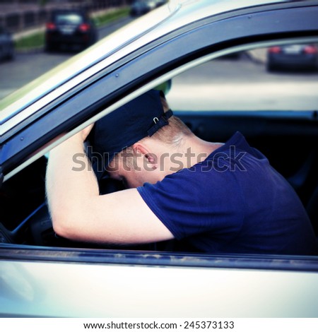 Toned Photo of Tired Man fall asleep in a Car