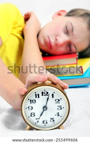 Kid sleep with Alarm Clock on the Bed. Focus on the Clock