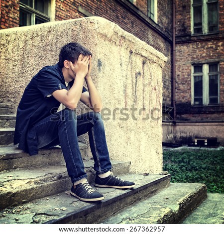 Toned Photo of Sad Teenager on the Landing Steps of the Old House