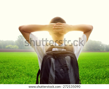 Toned Photo of teenager with knapsack in the summer field