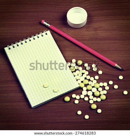Toned Photo of Writing Pad and the Pills on the Wooden Table