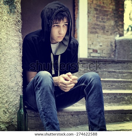 Toned Photo of Sad Teenager on the landing steps of the Old House