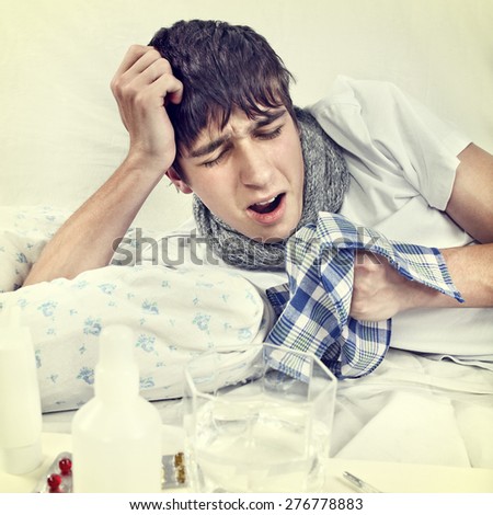Toned Photo of Sick Young Man on the Bed with Handkerchief