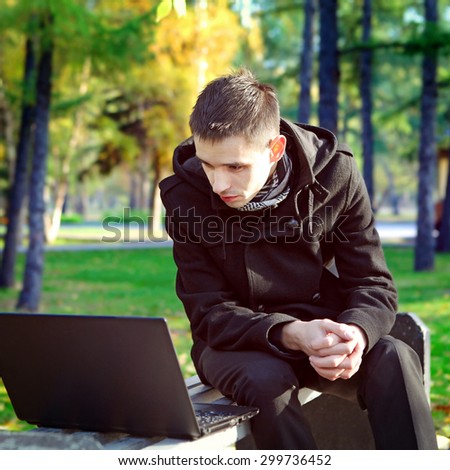 Toned Photo of Young Man with Laptop in the Autumn Park