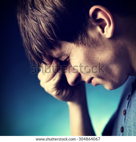 Toned Photo of Sad Young Man on the Dark Background closeup