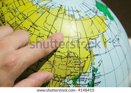 finger pointing the globe map russia