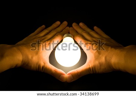 Hand and a Bright Light Bulb, Concept of Inspiration, Ideas
