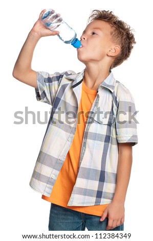 Happy boy drinks water from a bottle isolated on white background