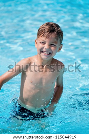Happy teen boy in pool at aqua park