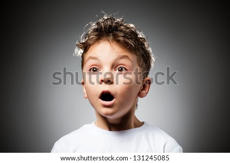 Portrait of boy surprised on gray background