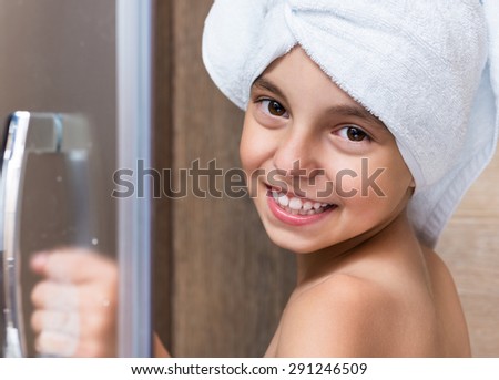 Portrait of girl with towel on head. Girl takes a shower in the bathroom.