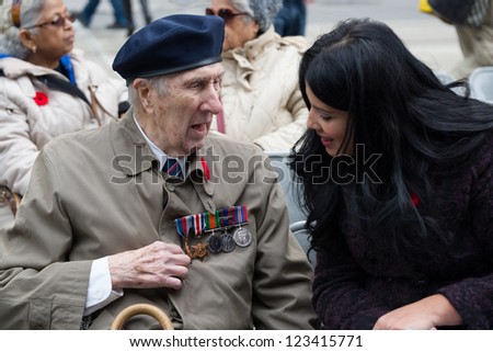 TORONTO - NOVEMBER 11: Young journalist checks out the hardware on a veteran after Remembrance Day Services at Old City Hall Cenotaph on November 11, 2012.