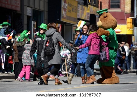 TORONTO - MARCH 17: People take photos with the mascot. Toronto\'s annual St. PatrickÃ?Â¢??s Day parade takes place under sunny skies on Sunday afternoon March 17, 2013 in Toronto.