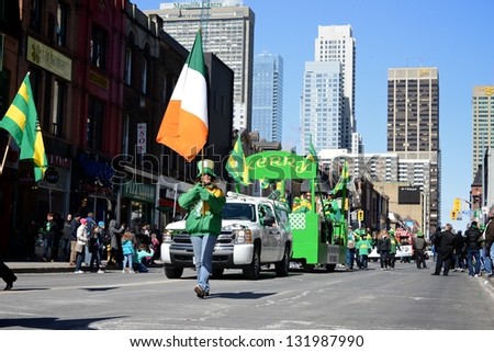 TORONTO - MARCH 17: People holds Irish flag on the street. Toronto\'s annual St. Patrick\'s Day parade takes place under sunny skies on Sunday afternoon March 17, 2013 in Toronto.