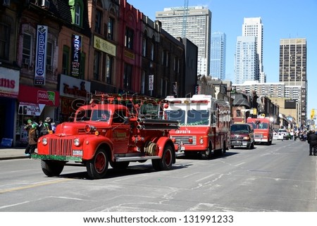 TORONTO - MARCH 17: People take photos at the parade. Vintage firetrucks drive on the street. Toronto\'s annual Patrick\'s Day parade takes place under sunny skies on Sunday afternoon March 17, 2013.