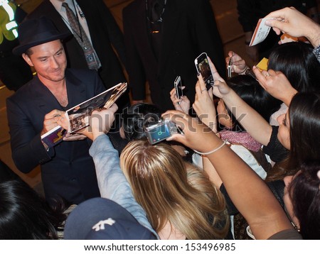 TORONTO - SEPTEMBER 8: Actor Jude Law signs autographs for fans at the Toronto International Film Festival for her new film Dom Hemingway on September 8, 2013.