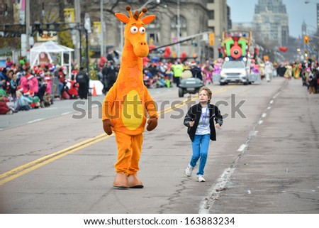 TORONTO - NOVEMBER 17: People disguised as a giraffe attends 109th Toronto Santa Claus Parade in Toronto, Canada on November 17, 2013.