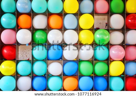 Wall of balloons with some popped, carnival game