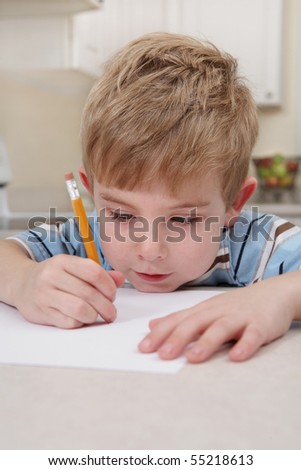 Young boy drawing with a pencil