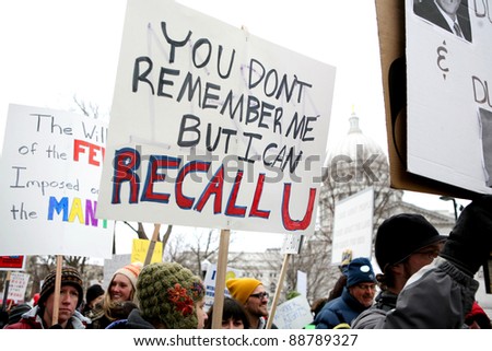 MADISON,WI - FEB 19: Signs are lifted in front of Wisconsin\'s Capitol protesting Gov Scott Walker on Feb 19, 2011 in Madison, WI.  The Wisconsin drive to recall Walker starts Nov 15.