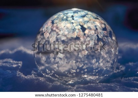 Image in a science experiment series of frozen bubble with ice crystals, ice crystals just starting to fill bubble, shallow focus