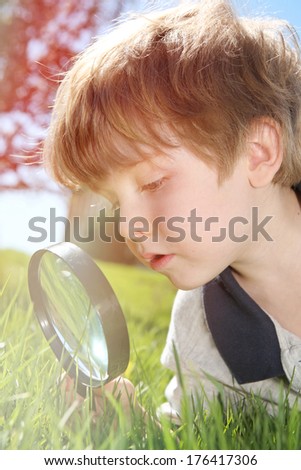 Young boy looking through a magnifying glass