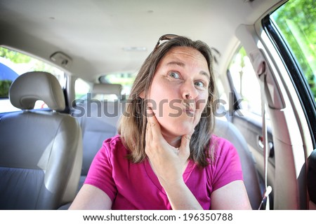 Woman checking her face in the mirror before driving