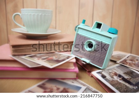 Still life with vintage camera and photos. Blur effect, focus on camera