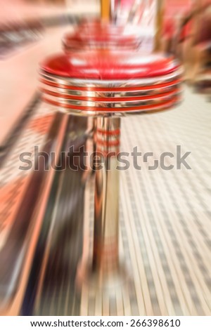 Red vinyl stools in a vintage diner. Motion blurred effect