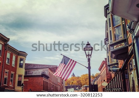 Shops along main street, Galena, Illinois, focus on flag, vintage toned image.