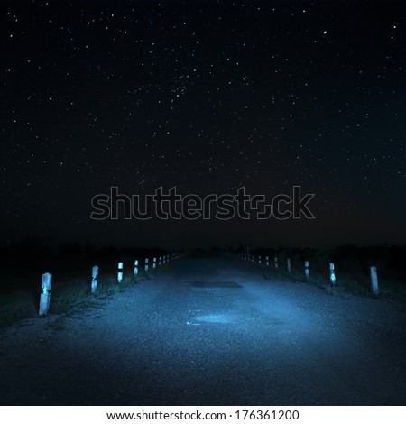 Local asphalt road at night with stars background and no roadway lighting