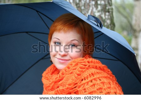 young red-haired woman in red scarf with umbrella