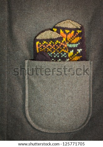 Vintage wool knitted mittens in the coat pocket. With space for your text.