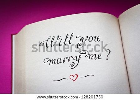 Will you marry me? vintage style words in the open book with pink background. Created with love.