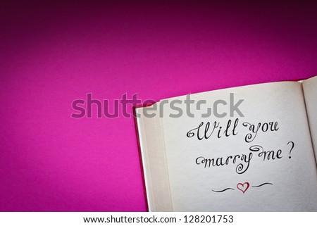 Will you marry me? hand drawn words in the open book with pink background\
Created with love.