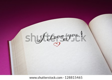 I love you! words and red heart in the open book with pink background.