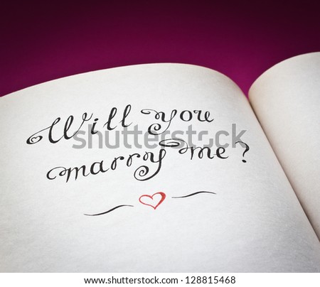 Will you marry me? words and red heart in the open book. Created with love.
