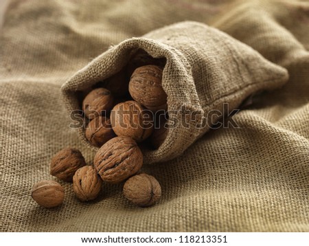 walnuts in woven bag on woven cloth