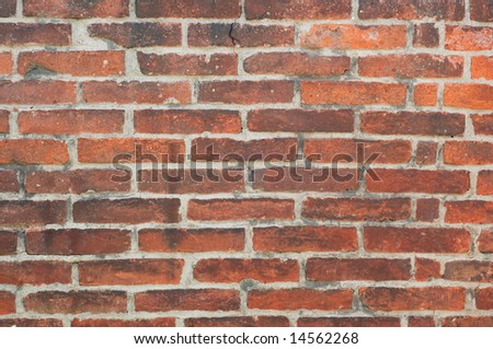 An old red wall background made of bricks and mortar.