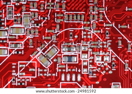 Detail of red printed circuit board with electronic components.