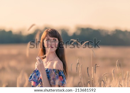 Beautiful Model girl Dressed in Casual Dress on the Field in Sun Light.