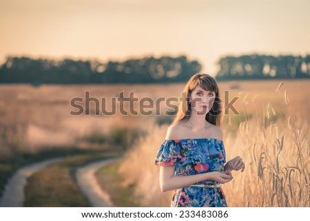 Beautiful Model girl Dressed in Casual Dress on the Field in Sun Light