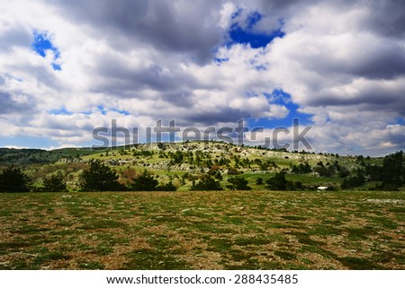 Beautiful spring landscape of the Crimea - the plateau of AI-Petri mountain, with low hills and cloudy sky