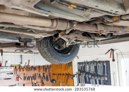 Auto service shop has lift for easy working on underside of car