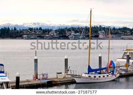 Yachts with 3 mothballed aircraft carriers in the background. The carriers are the U.S.S. Ranger, the U.S.S. Kitty Hawk, & the U.S.S. Independence, floating at the Navy Base in Bremerton, Washington.
