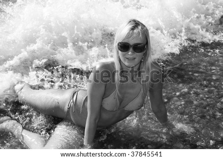 Young girl in dark sun-glass on a coast of Black sea. Black and white photo
